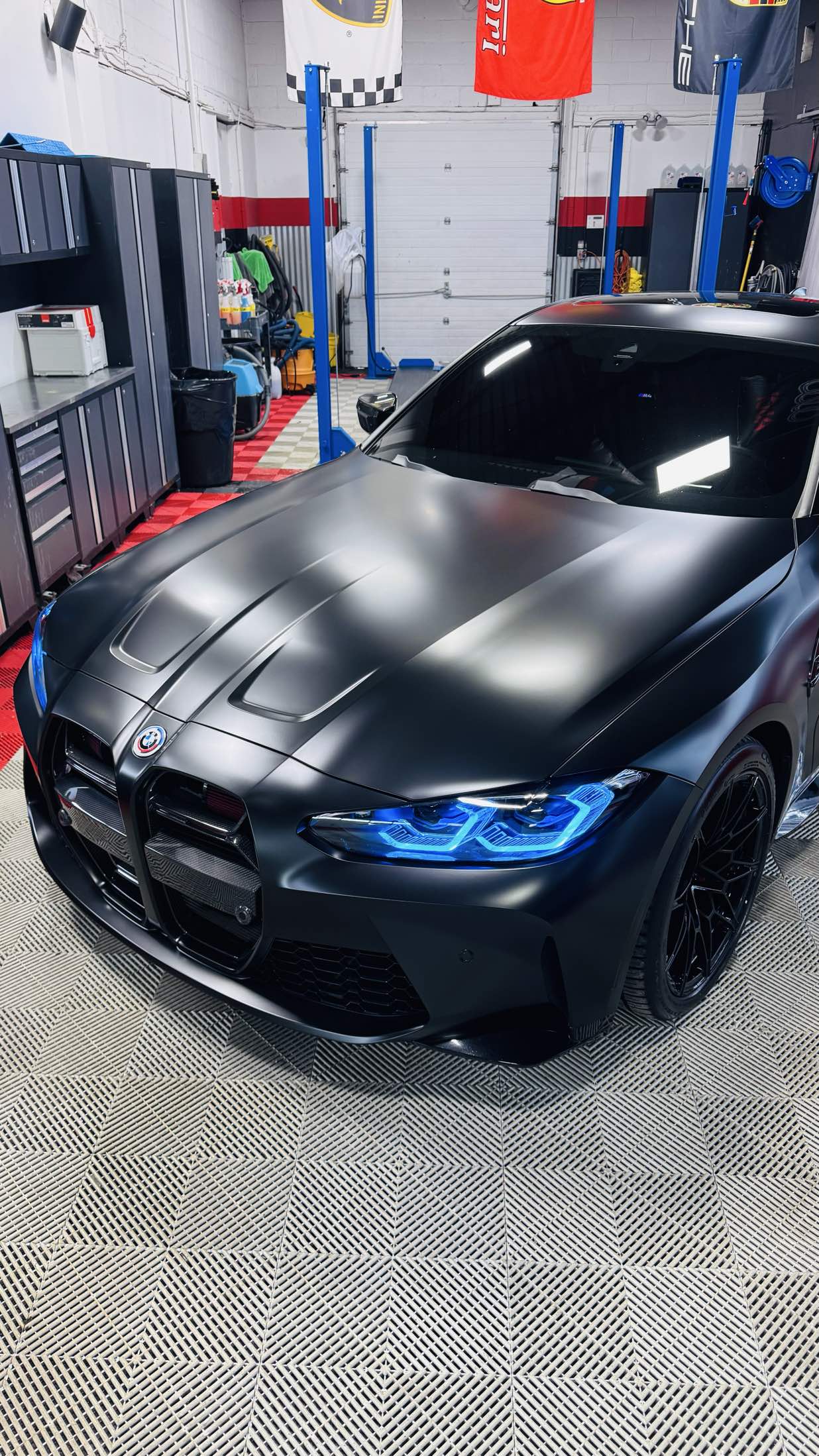 Matte black BMW M4 with blue headlights